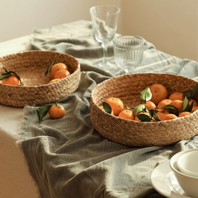 Low round woven basket filled with oranges