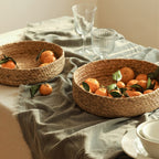 Low round woven basket filled with oranges