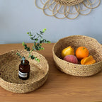 Low round woven basket filled with oranges