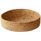 Low round woven basket filled with oranges