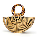 Structured handbag in sculpted natural wood with a hand woven rattan body
