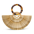 Structured handbag in sculpted natural wood with a hand woven rattan body