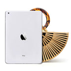 Structured handbag in sculpted natural wood with a hand woven rattan body