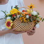 Three mini woven flower baskets with handles and flowers