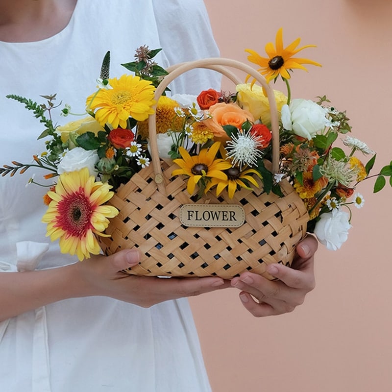 Three mini woven flower baskets with handles and flowers