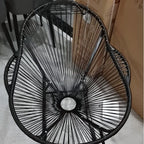Modern rocking chair hand woven in black rattan with generous curves