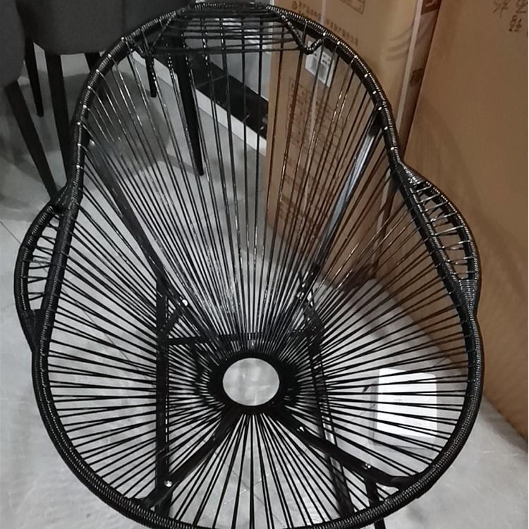Modern rocking chair hand woven in black rattan with generous curves