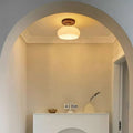 Modern ceiling light with a wood frame and translucent glass stone diffuser