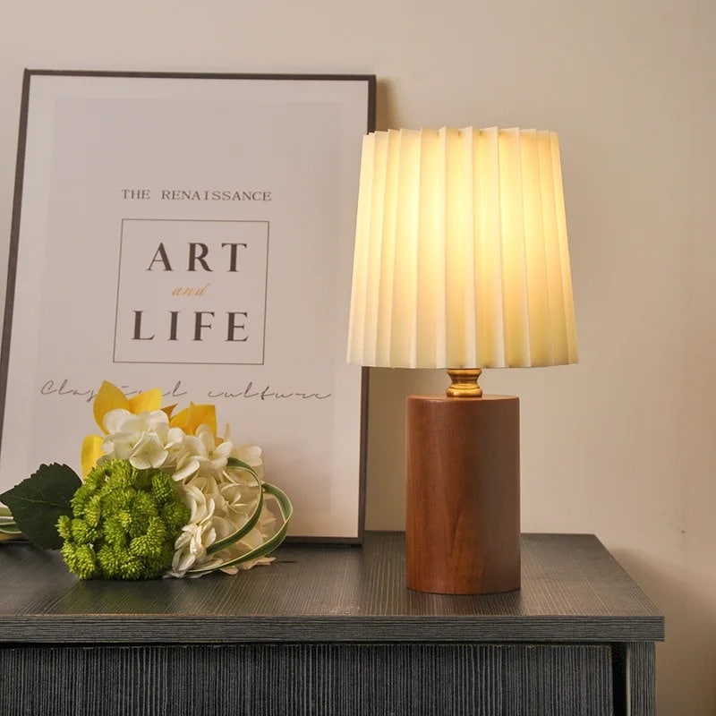 Modern bedside lamp with a shaped brown wood base and a fabric shade