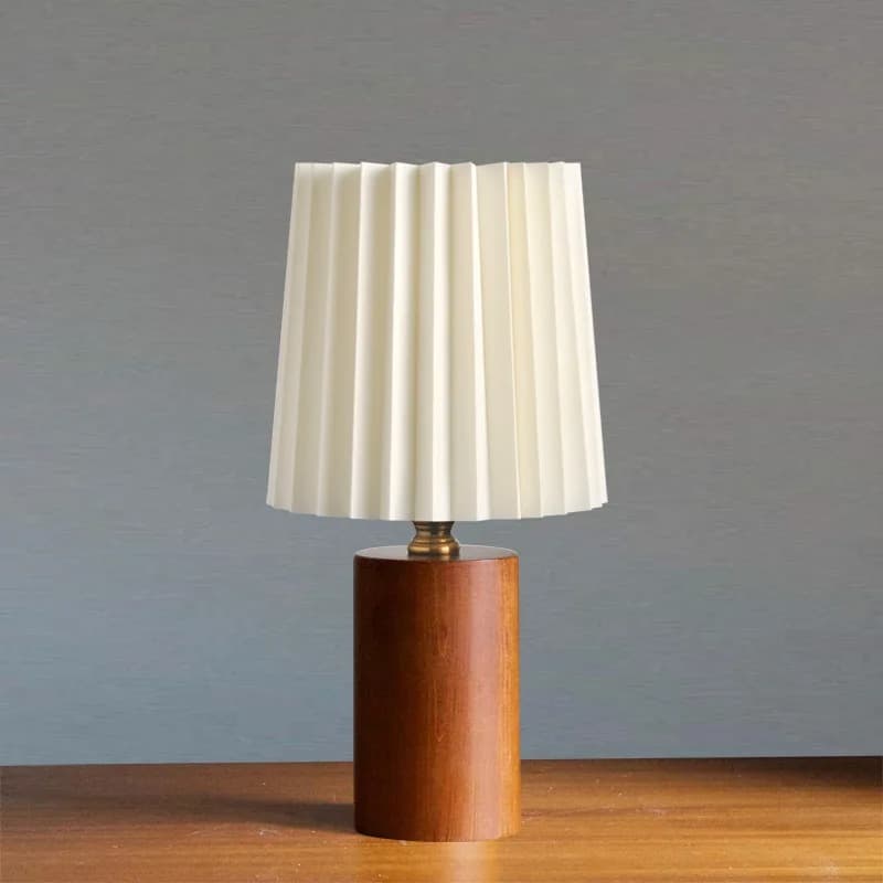 Modern bedside lamp with a shaped brown wood base and a fabric shade