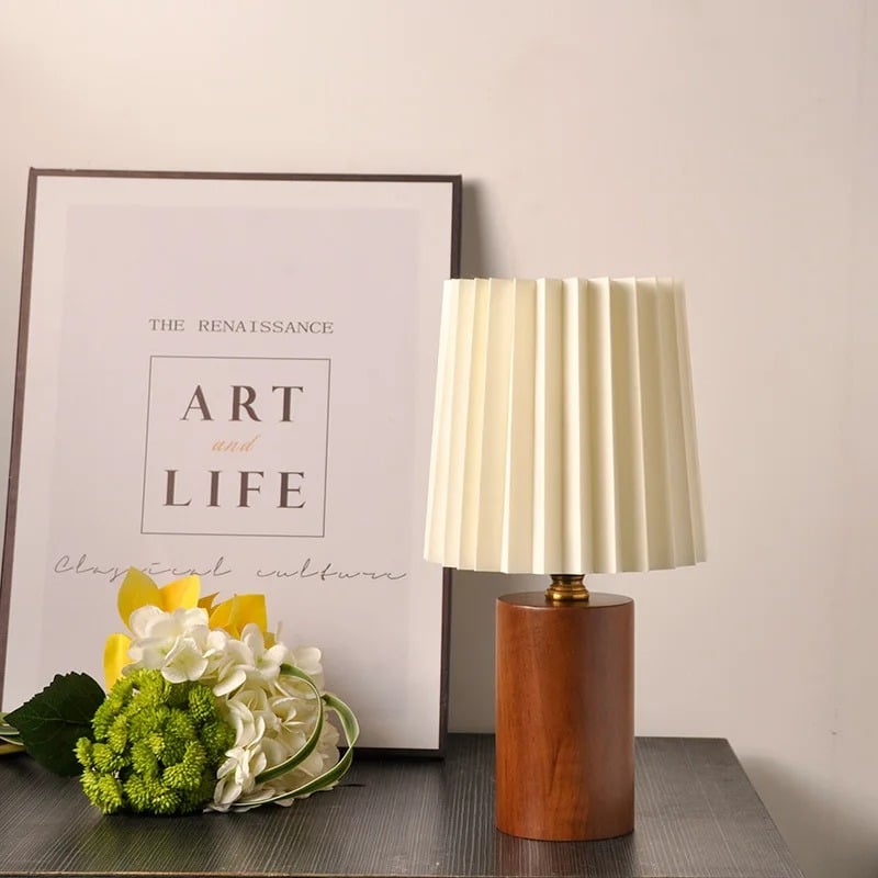 Modern bedside lamp with a shaped brown wood base and a fabric shade