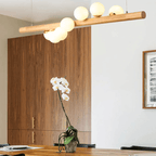 Long modern pendant with a natural wood frame and glass globes
