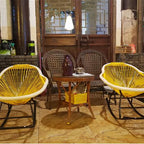 Modern rocking chair hand woven in sunny yellow rattan with generous curves