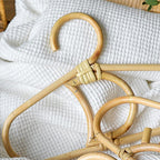 Kids' clothes hanger hand woven in natural rattan in a moon shape