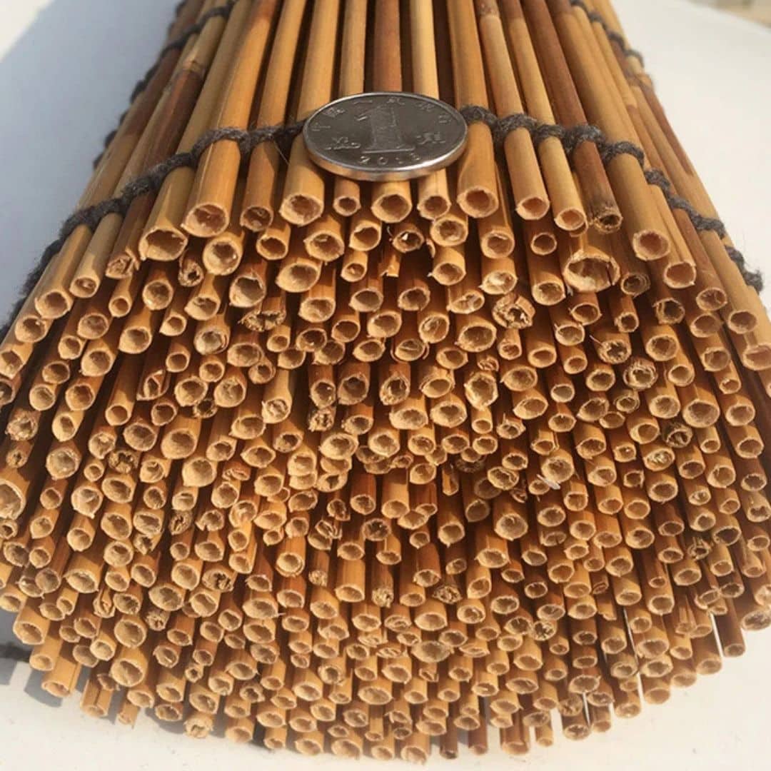 Roll up blind made of round natural stems tied with cord, rolled at the bottom