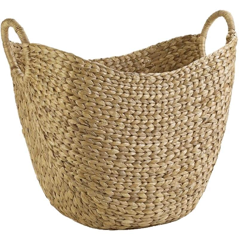 Wide natural woven laundry basket with handles holding throws