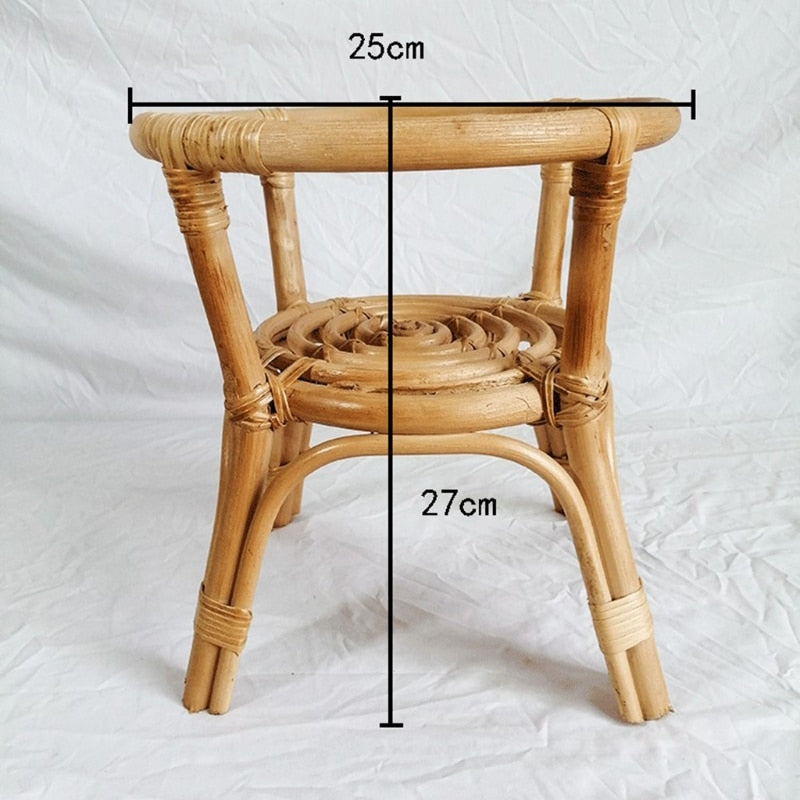 Hand woven natural rattan plant stand holding a potted plant