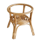 Hand woven natural rattan plant stand holding a potted plant