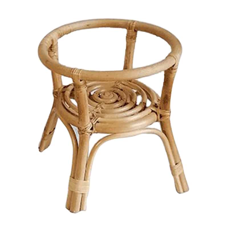 Hand woven natural rattan plant stand holding a potted plant