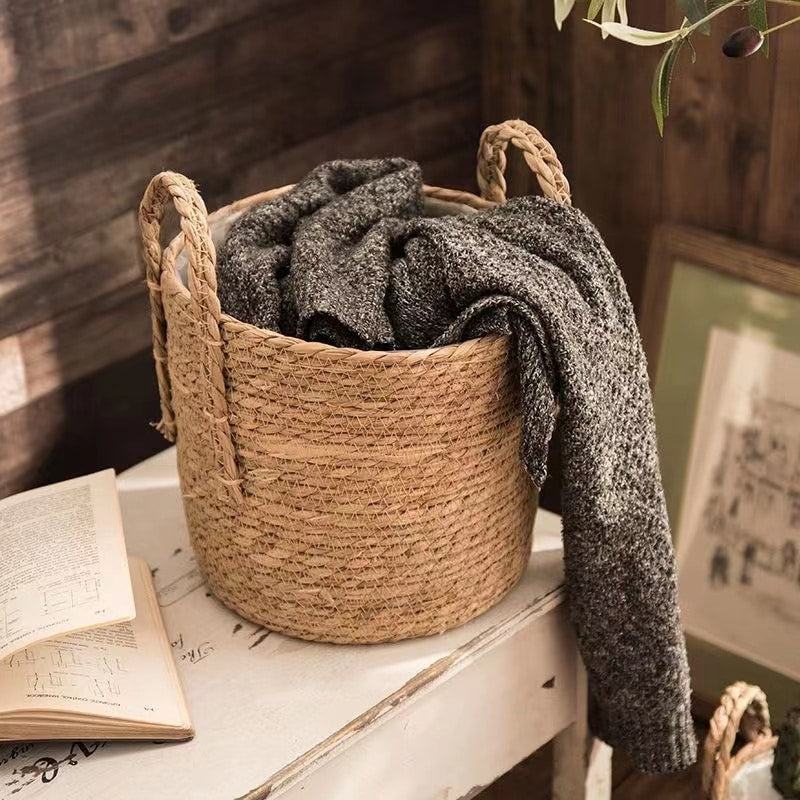 Natural woven storage baskets with handles and plants