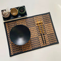 Rectangular woven bamboo placemat with a two tone beige and black checkered pattern