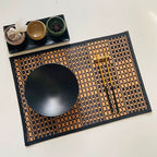 Rectangular woven bamboo placemat with a two tone beige and black checkered pattern