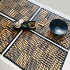Rectangular woven bamboo placemat with a two tone beige and black checkered pattern