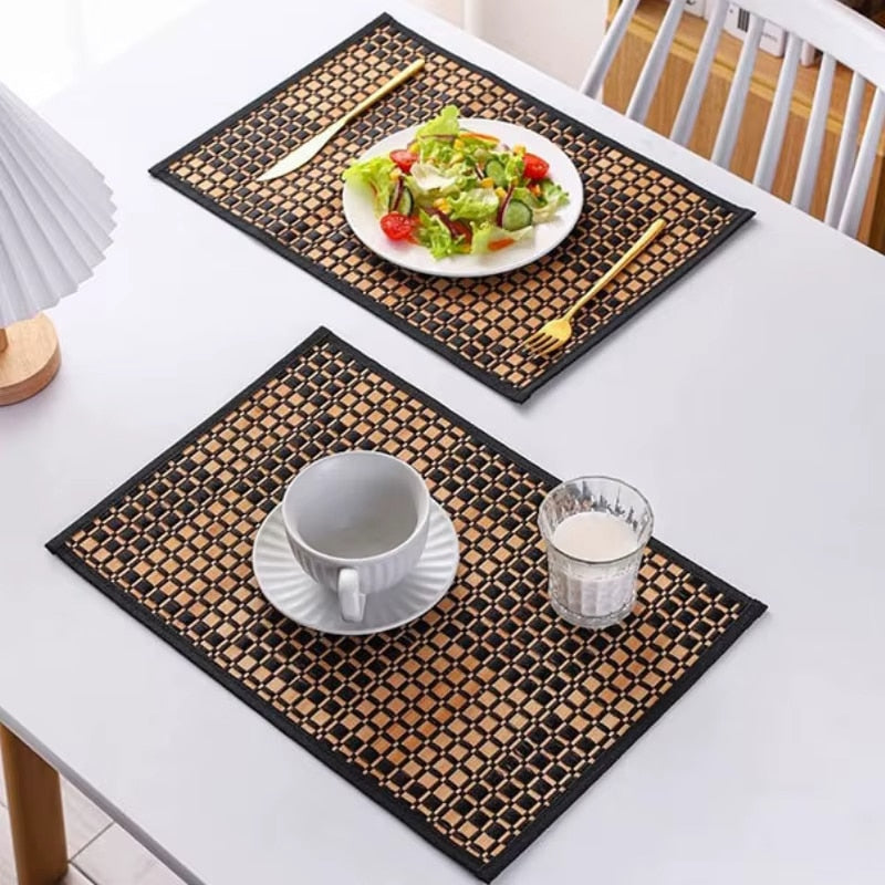 Rectangular woven bamboo placemat with a two tone beige and black checkered pattern