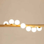 Linear wooden chandelier with seven frosted glass globes over a dining table
