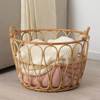 Open frame rattan basket holding folded blankets