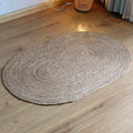 Small oval braided jute rug on a wood floor