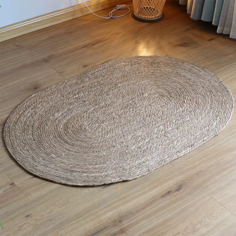 Small oval braided jute rug on a wood floor