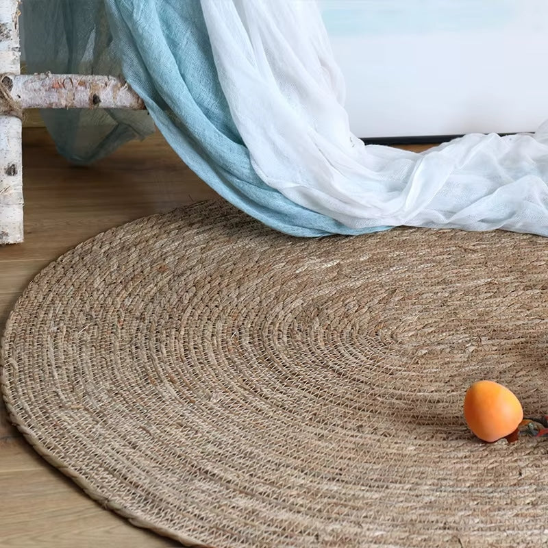 Small oval braided jute rug on a wood floor