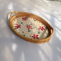 Oval rattan tray with red floral pattern and woven border