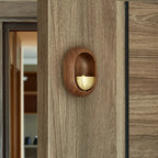 Brass bell inside an oval dark wood frame for a door