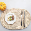 Oval placemat hand woven in golden dried corn husk