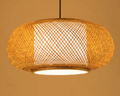Rounded oval woven rattan drum pendant glowing warm