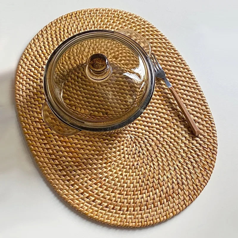 Large oval hand woven rattan serving mat under a glass casserole