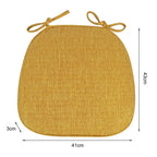 Yellow padded polyester seat cushion with ties for a rattan chair
