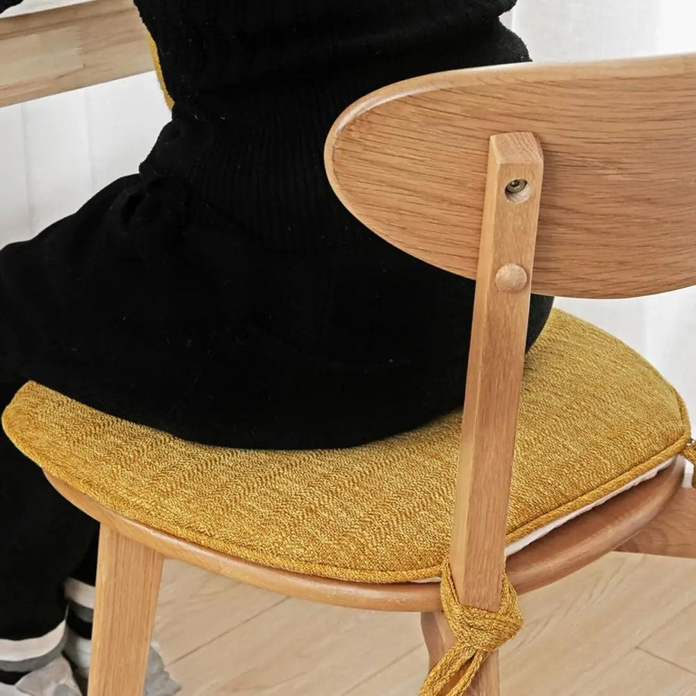 Yellow padded polyester seat cushion with ties for a rattan chair