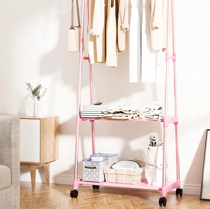 Pink wood look rolling clothes rack with a hanging rail and lower shelf on casters