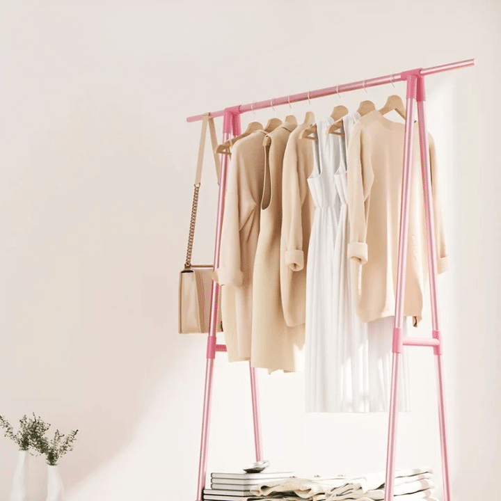 Pink wood look rolling clothes rack with a hanging rail and lower shelf on casters