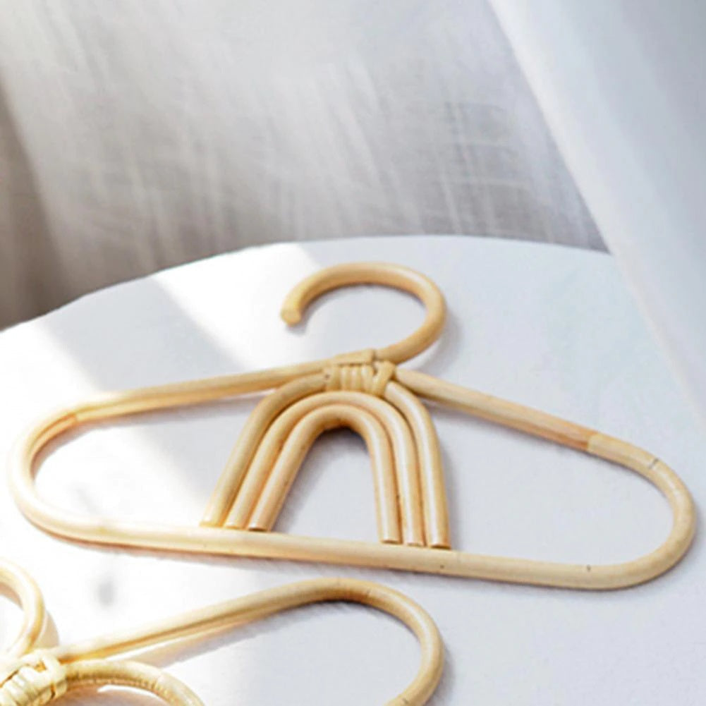 Kids' clothes hanger hand woven in natural rattan in a rainbow shape
