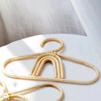 Kids' clothes hanger hand woven in natural rattan in a rainbow shape