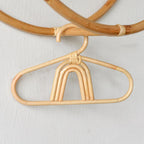 Kids' clothes hanger hand woven in natural rattan in a rainbow shape