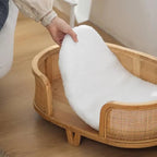 Raised wicker dog bed with tapered legs and cushion
