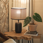 Desk lamp with a hand woven rattan shade on a matte black metal base