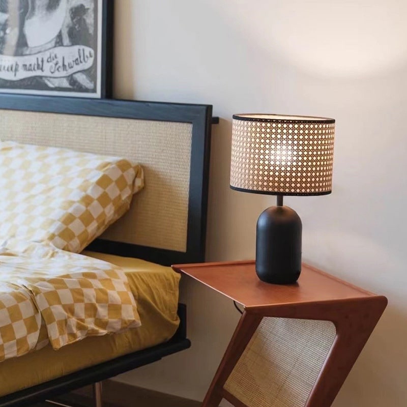 Desk lamp with a hand woven rattan shade on a matte black metal base