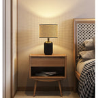 Desk lamp with a hand woven rattan shade on a matte black metal base