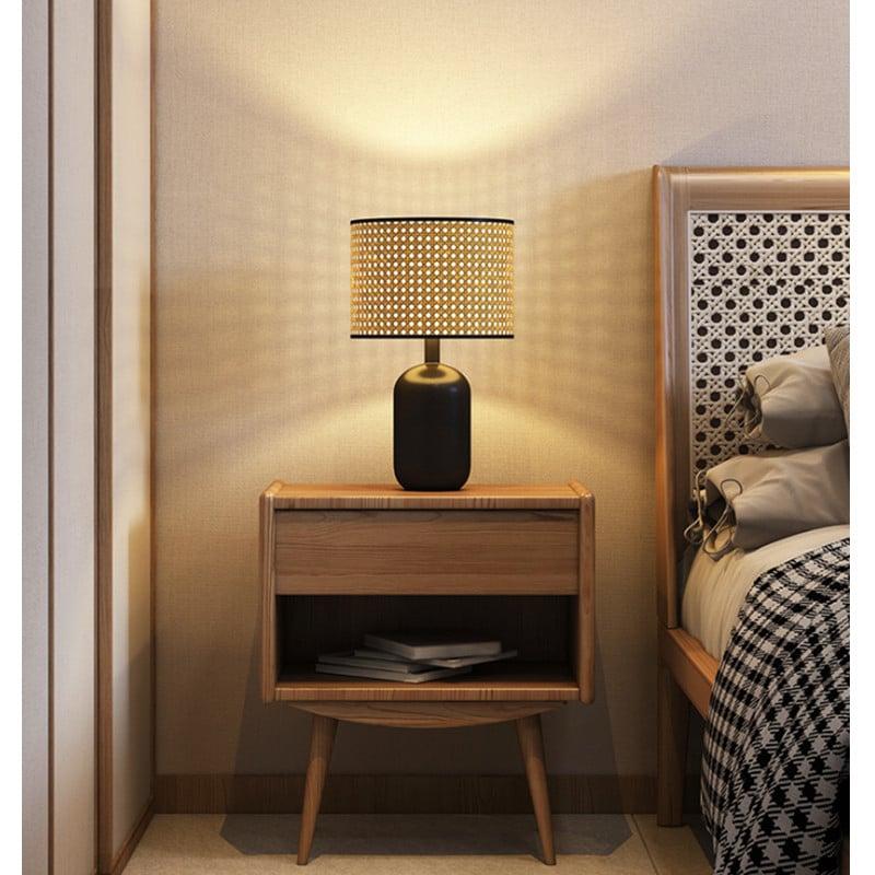 Desk lamp with a hand woven rattan shade on a matte black metal base